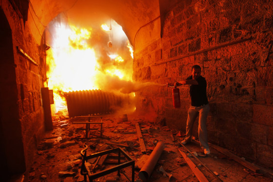 Image: A Palestinian man tries to extinguish a fire during clashes with Israeli police in Jerusalem