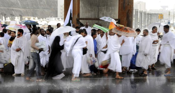 Image: Pilgrims attending the hajj shelter from heavy rains