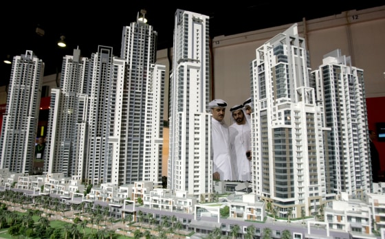 Image: Emirati men look at models of buildings
