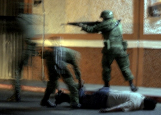 Image: Mexican soldiers detain an unidentified man during a navy operation in Cuernavaca
