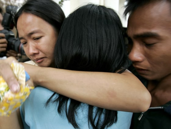 Image: Relatives embrace after a ferry collided with a fishing boat