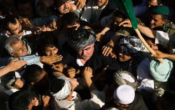 Image: A crowd welcomes Afghan General Dostum from exile in Turkey during a ceremony in Shibergan