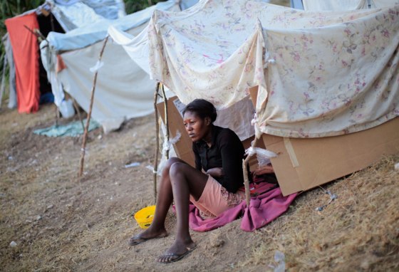 Image: A woman sits at her tent at a makeshift camp in Port-au-Prince, Haiti