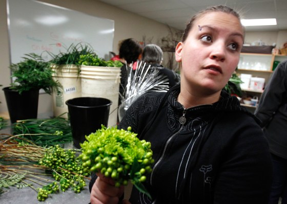 Image: Chappell makes a bouquet, to be handed to an Olympic athlete, at a flower shop in Surrey