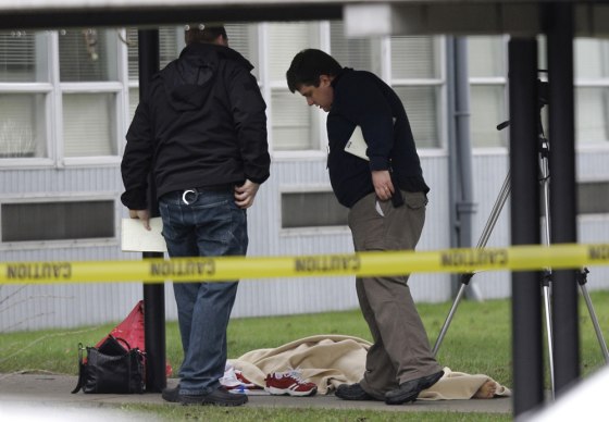 Image: Forensics investigators view the blanket-covered body of a special education teacher