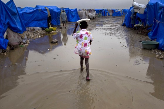 Image: Girl walks through flooded survivors camp in Haiti