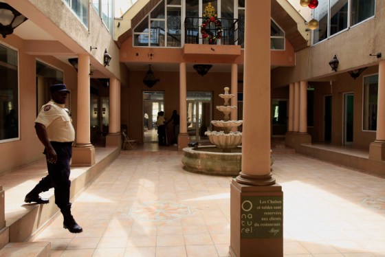 Image: A police officer walks by the hall of the former Gold Gym shopping in Port-au-Prince