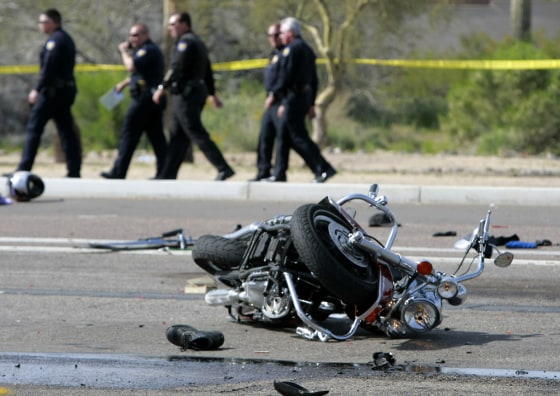 Phoenix police detectives look over the scene of a accident involving multiple motorcycles and a trash truck on the Carefree Highway in Phoenix.