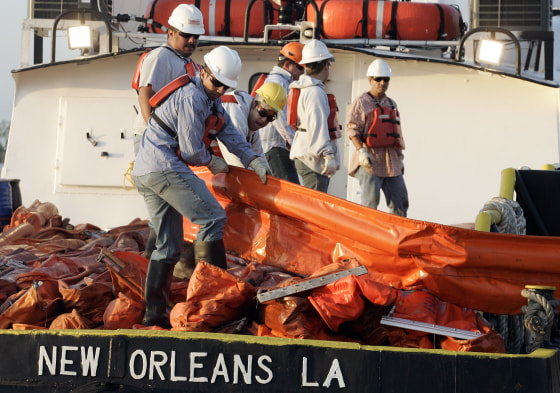 Image: Workers load oil booms onto a crew boat to assist in the containment of oil from a leaking pipeline in the Gulf of Mexico