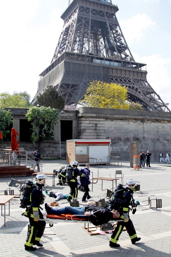 Image: French firemen give first aid to mock injured people as they conduct a drill exercise on terror attacks near the Eiffel Tower in Paris