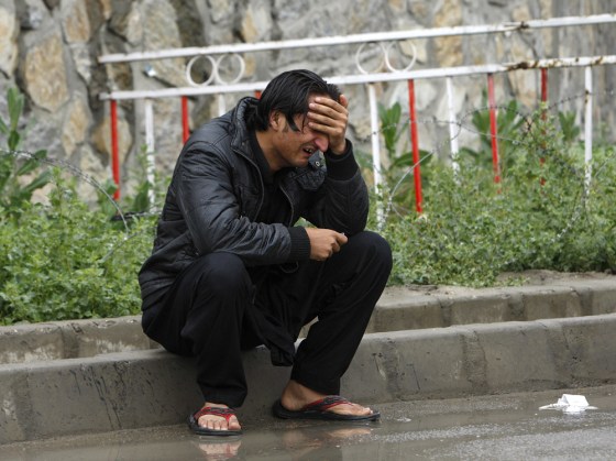 Image: A man grieves outside the airport terminal in Kabul