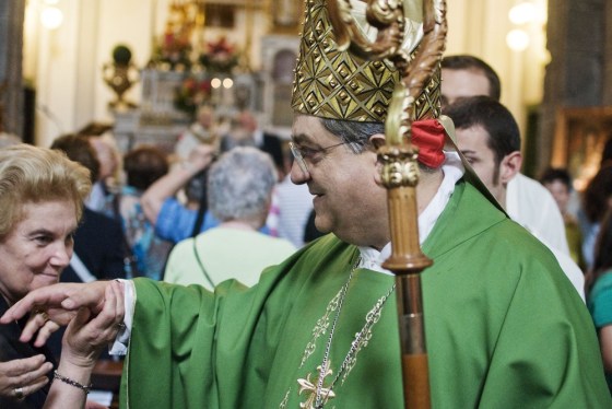 Image: The faithful hold the hand of Cardinal Crescenzio Sepe at the Saint Onofrio dei Vecchi church after his mass in Naples