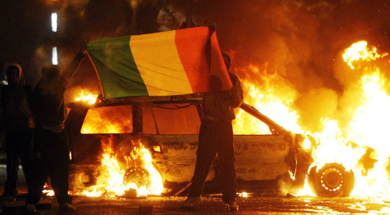 Image: Nationalist protesters brandish the Irish tricolour flag during clashes with police in Belfast