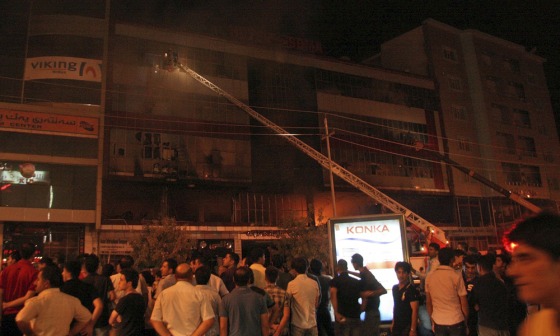Image: Iraqis gather as firefighters respond to a fire