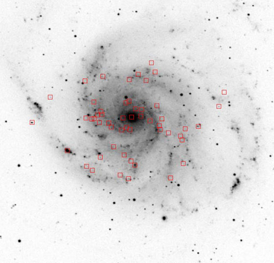 In this negative image of the Pinwheel Galaxy (M101), red squares mark the positions of "super-soft" X-ray sources. The Pinwheel should contain hundreds of accreting white dwarfs on which nuclear fusion is occurring, which should produce prodigious X-rays. Yet detected are only a few dozen super-soft X-ray sources. 