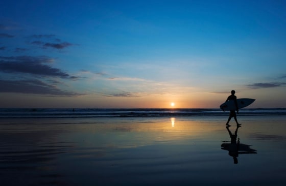 Image: Surfer on Playa Carmen beach at sunset.