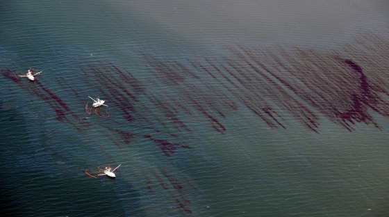 Image: Fishing boats drag booms through an oil slick