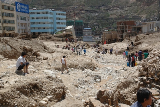 Image: A view shows buildings, vehicles and roads buried after a landslide hit Zhouqu County of Gannan Tibetan Autonomous Prefecture
