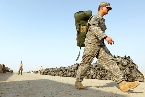 Image: A U.S. soldier carries his bag as he prepares to pull out from Iraq