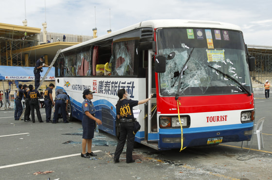 Image: Philippine National Police inspects the damage to a tourist bus during forensic examinations in Manila