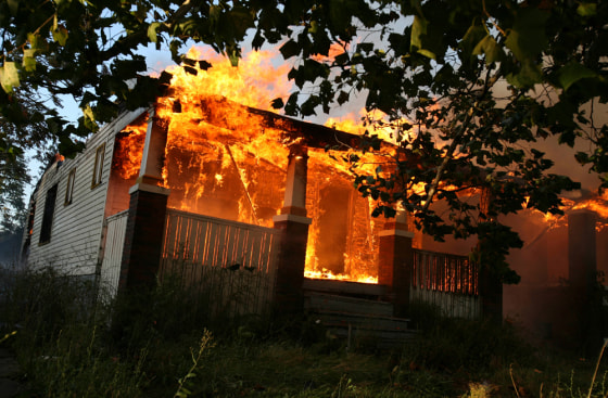 Flames engulf a home on Detroit's east side Tuesday. Fire officials say flames swept through dozens of homes in Detroit, fanned by strong winds that toppled power lines across the city.