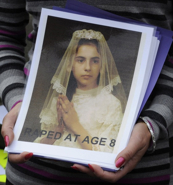 Image: Therese Albrecht and Barbara Blaine hold a picture of themselves during a protest by people assaulted by priests at St Mary's cathedral in Edinburgh