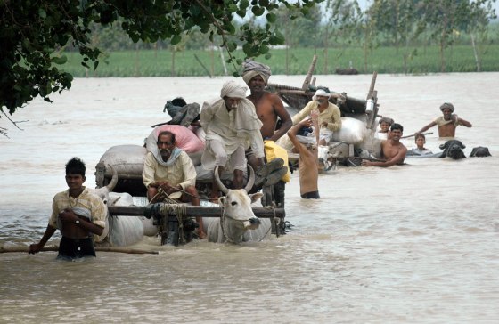 Indian villagers move through floodwaters.