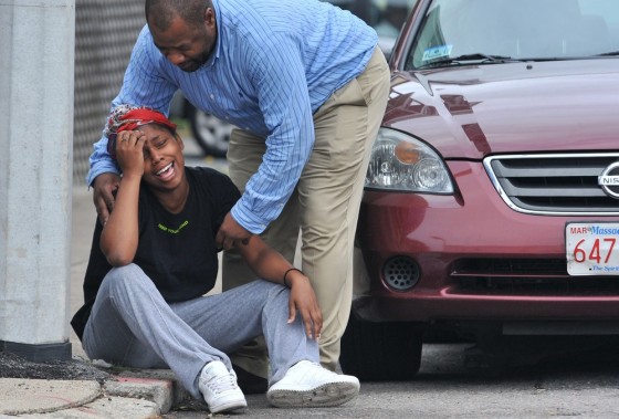 Image: A man comforts a grieving woman near the scene of a shooting i