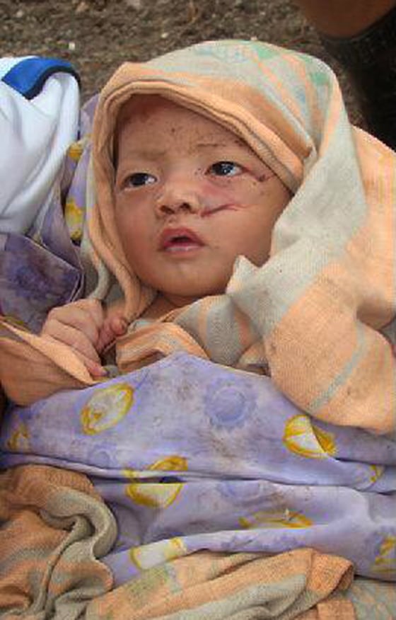 Image: Villager holds a baby survivor, orphaned by the tsunami which hit Muntei Baru Baru village, in the Cikakap subdistrict of Indonesia's Mentawai islands