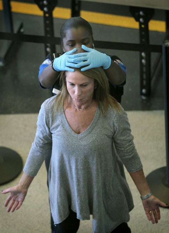 Image: An airline passenger gets patted down after going through a full-body scan at O'Hare Airport