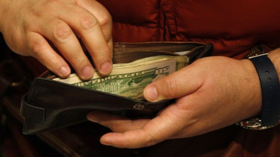 Image: A customer opens his wallet at a Macy's cash register on Black Friday in New York
