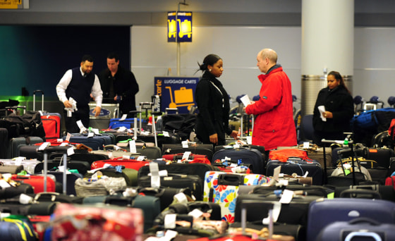 Image: American Airlines worker helps travellers with luggage at John F. Kennedy International Airport