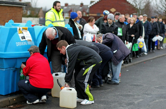 Image: People queue to fill bottles and tanks w