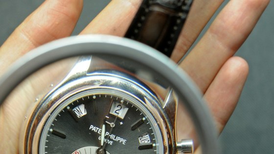 Image: An employee holds a magnifying glass as