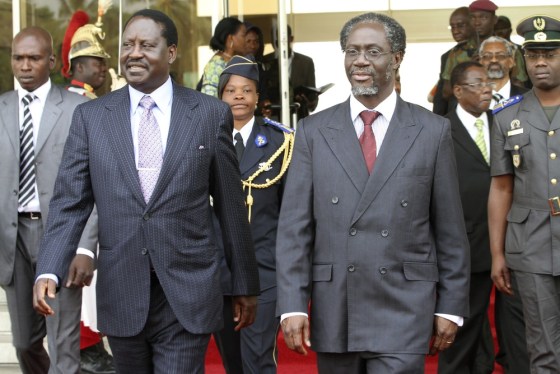 Image: Kenya's Prime Minister Odinga walks with Gilbert Ake in Abidjan