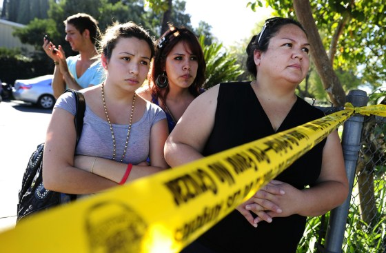 Image: Family members wait for their children o