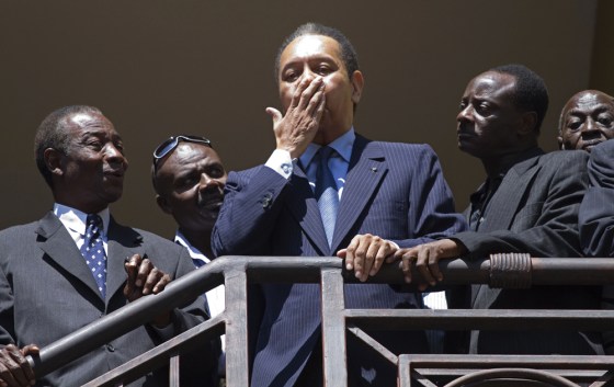 Image: Haiti's former dictator Jean-Claude 'Baby Doc' Duvalier, center, gestures to supporters