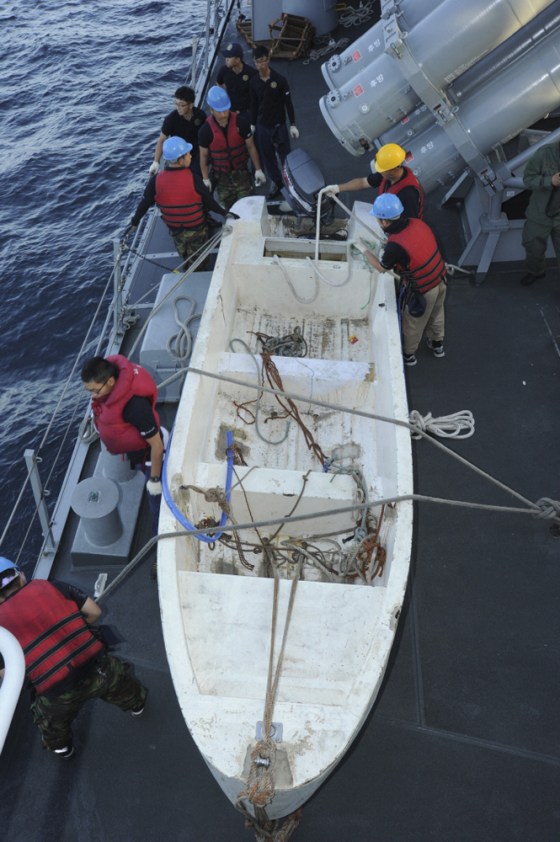 Image: South Korean navy personnel secure a boat used by Somali pirates which was captured in the Arabian Sea