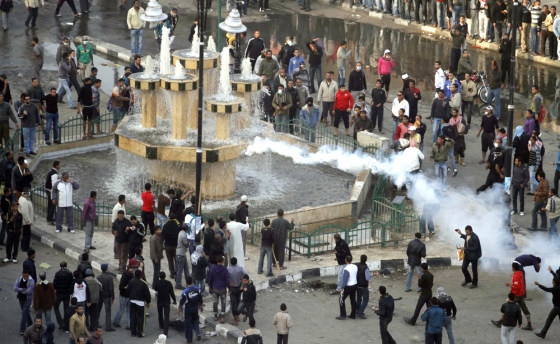 Image: Anti-government demonstrators watch as tear gas is fired by police in an attempt to disperse them in the port city of Suez