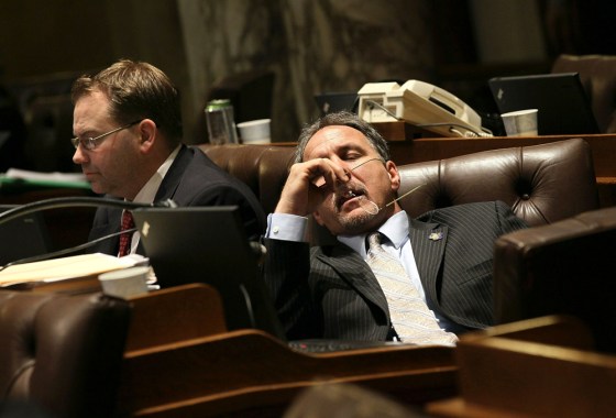 Image: Wisconsin State representatives start to fade as they listen to arguments on one of the expected 200 amendments to Gov. Scott Walker's budget repair bill in the early morning hours
