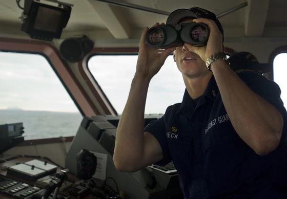 Lt. J.G. Ryan Beck checks out a boat in the distance while on patrol off the San Diego coast.