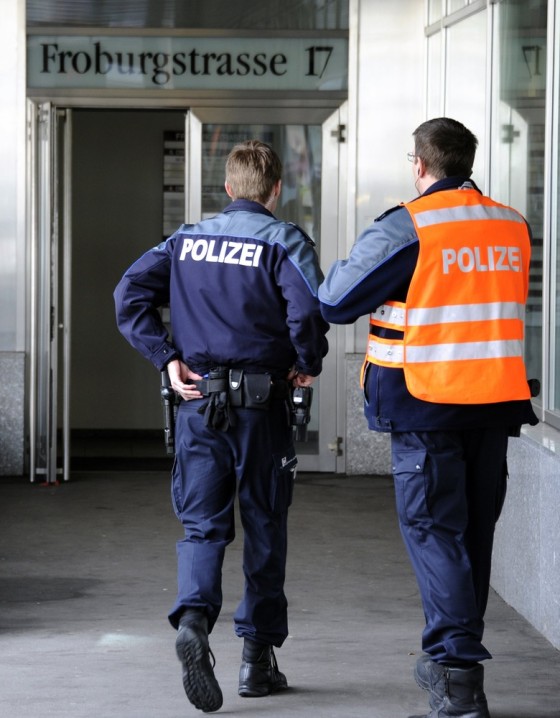 Image: Policemen stand in front of the entrance of Swiss nuclear power industry association, on March 31, 2011 in Olten. Two people were injured when a letter bomb exploded at the offices of the association.