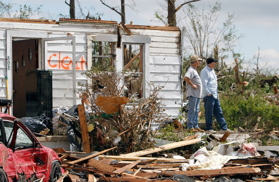 Image: People look at tornado damage