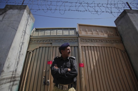 Image: A policeman stands guard outside one of two gates of the compound where al Qaeda leader Osama bin Laden was killed in Abbottabad