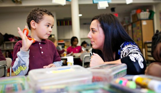 Erin Ferrantino helps Bernard Alexander, 5, at Rawson Elementary School in Hartford. Ms. Ferrantino says she has seen firsthand the challenges for kindergartners who start at 4 years old.