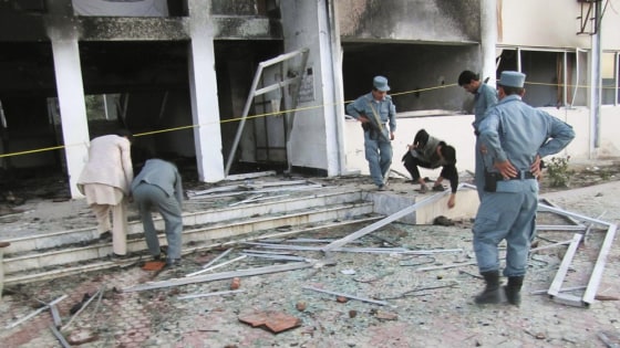Image: Afghan policemen inspect the outside of the governor office in Takhar province