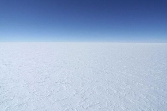 A view of the blue sky and bright white East Antarctic Ice Sheet from a DC-3 airplane.