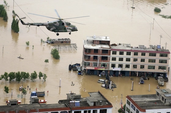 Image: a military helicopter flies over a flooded area in Fuzhou in China's Jiangxi province