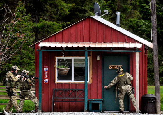 Missoula County sheriff's deputies sweep a rental cabin at the Lumberjack Saloon west of Lolo, Mont.