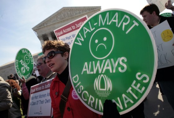 Image: File photo of protesters holding signs in front of the Supreme Court while class action lawsuit Dukes v. Wal-Mart is being argued inside the court in Washington